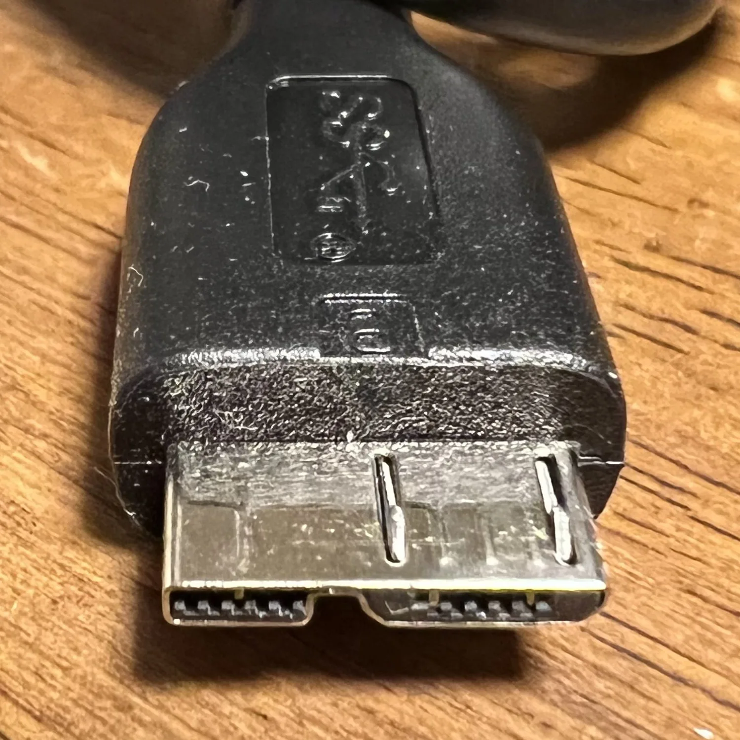 넓고 납작한 금속 테두리가 두 부분으로 나뉜 USB 3.0 Micro-B 플러그
